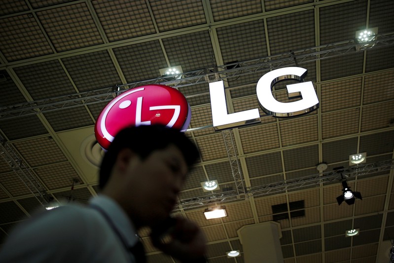 FILE PHOTO: A man talking on his phone walks past the logo of LG Electronics during Korea Electronics Show 2016 in Seoul