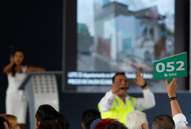 A man bids during an auction of seized properties from drug traffickers and others, in Mexico City