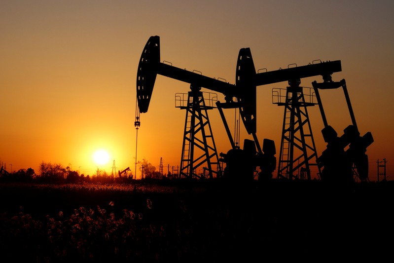 Pumpjacks are seen against the setting sun at the Daqing oil field in Heilongjiang