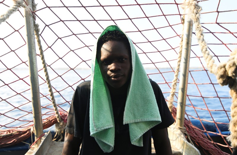 A migrant poses for a picture on board the rescue ship Sea-Watch 3 as it remains blocked one mile outside the port of Lampedusa