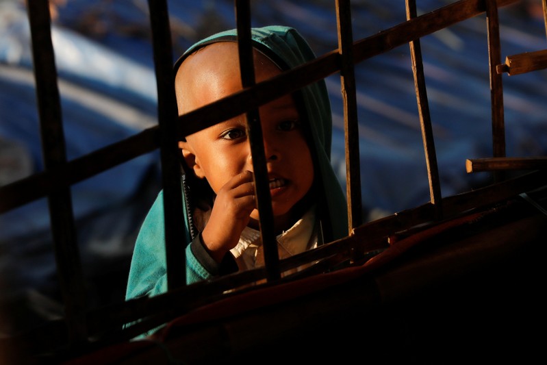 A Rohingya refugee child looks at others studying at a makeshift madrasa at the Burma Para refugee camp near Cox's Bazar