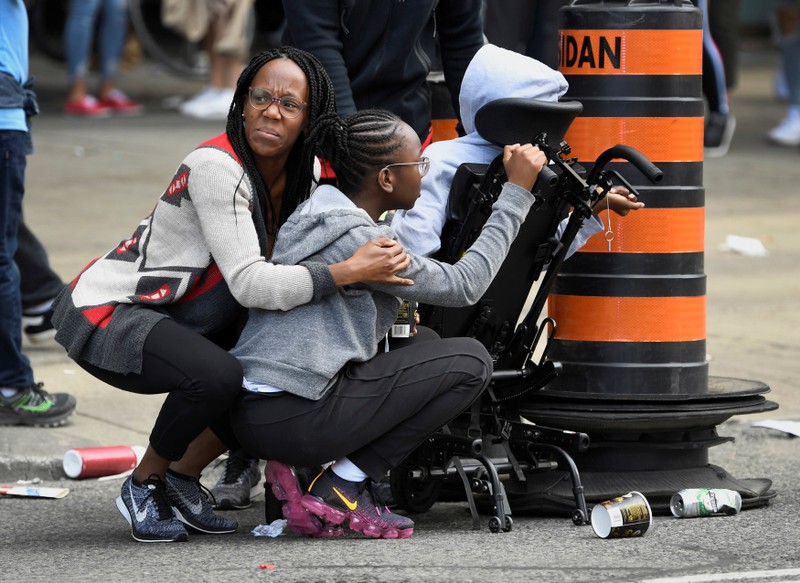People take cover after reports of shots fired at Toronto Raptors victory parade in Toronto