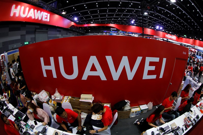 FILE PHOTO:Workers sit a the Huawei stand at the Mobile Expo in Bangkok