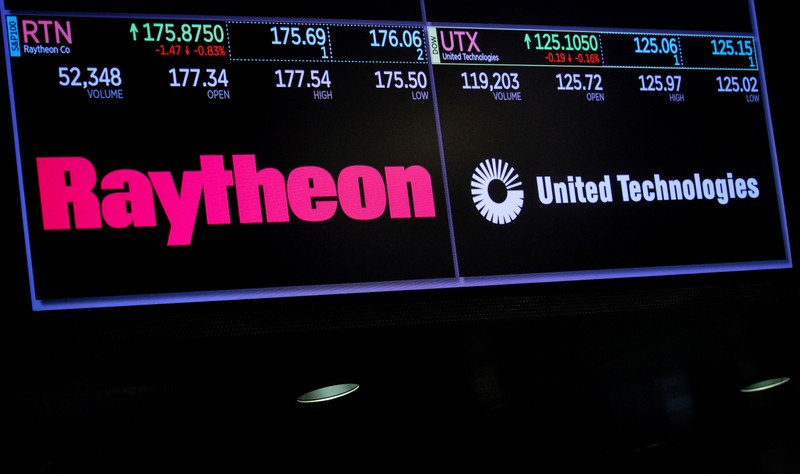 A screen shows the logos and trading information for defense contractor Raytheon Co, and United Technologies Corp. on the floor at the NYSE in New York