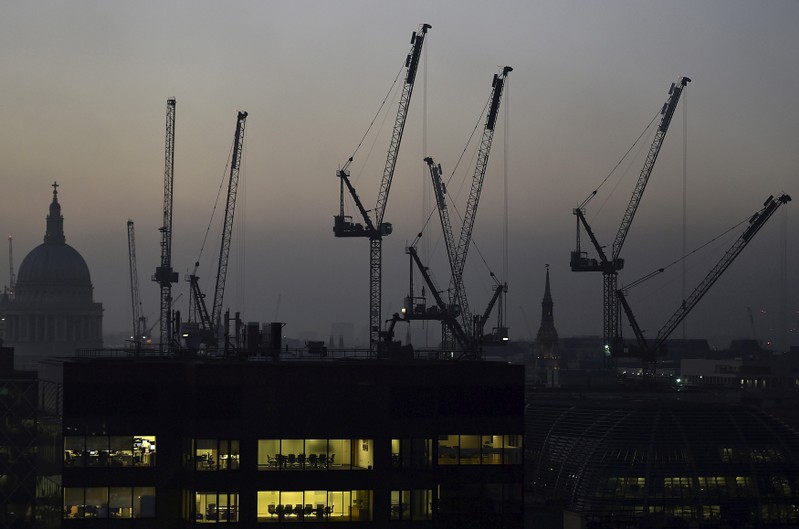 FILE PHOTO: Offices are seen at dusk as St. Paul's cathedral and construction cranes are seen on the skyline in the City of London
