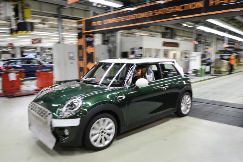 Workers assemble cars at the plant for the Mini range of cars in Cowley, near Oxford