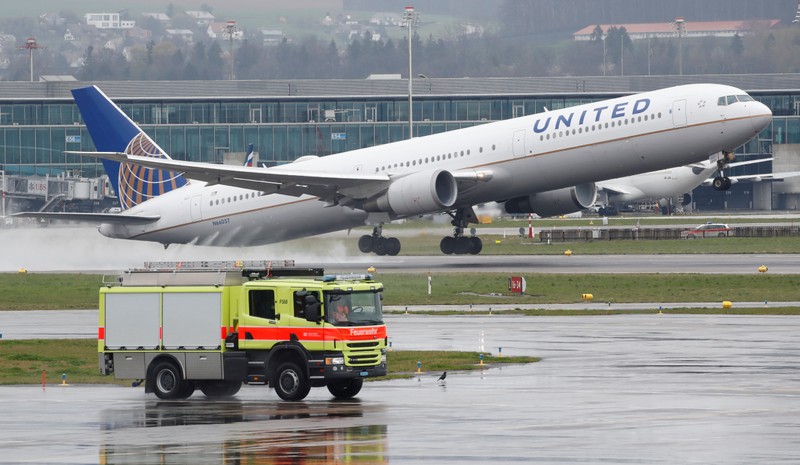 FILE PHOTO: A vehicle of the airport rescue and firefighting services stands in front as a Boeing 767 aircraft of United Airlines takes off from Zurich airport