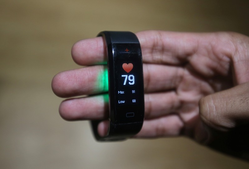 An employee displays the GOQii Vital activity tracker at their office in Mumbai
