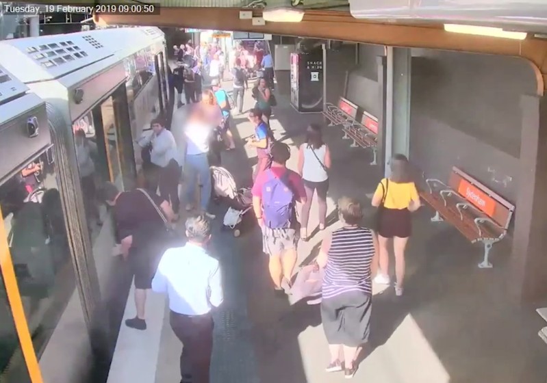 People look down between a train and platform, as a boy fell through train gap, in Sydney