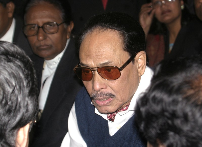 Bangladesh's former army ruler Ershad talks to his lawyers before entering a court in Dhaka