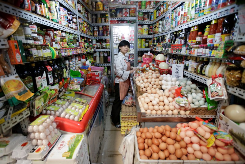A vendor is seen in her store at a supermarket in downtown Beijing
