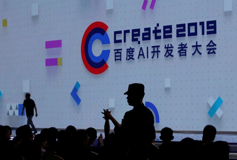 A security personnel stands guard among the delegates after a man poured a bottle of water over Baidu Inc Chief Executive Robin Li at the opening session of Baidu's annual AI developers conference in Beijing