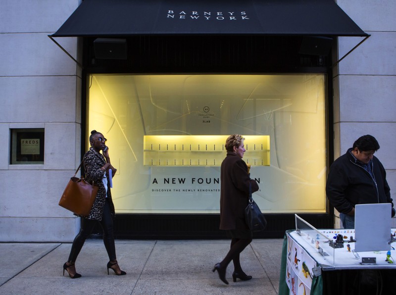 People walk by a Barneys New York retail store in New York