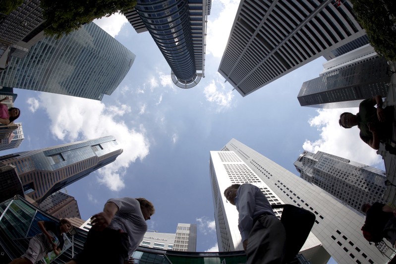 FILE PHOTO: People walking past office buildings at the central business district in Singapore