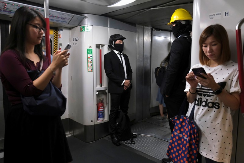 Anti-extradition bill demonstrators wearing helmets are seen inside a Mass Transit Railway (MTR) train in Hong Kong