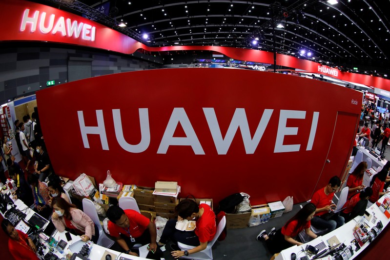 FILE PHOTO: Workers sit at the Huawei stand at the Mobile Expo in Bangkok