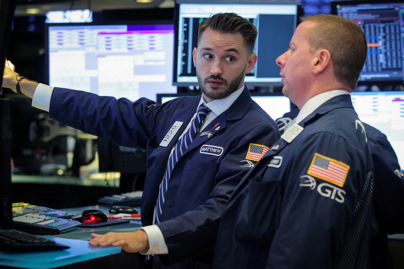 FILE PHOTO: Traders work on the floor at the NYSE in New York