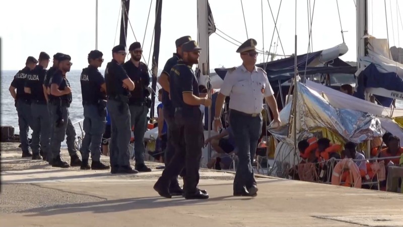 A still image from a video footage shows police officers guarding a migrant rescue boat, which docked at the port of Lampedusa in defiance of a ban on entering Italian waters, in Lampedusa