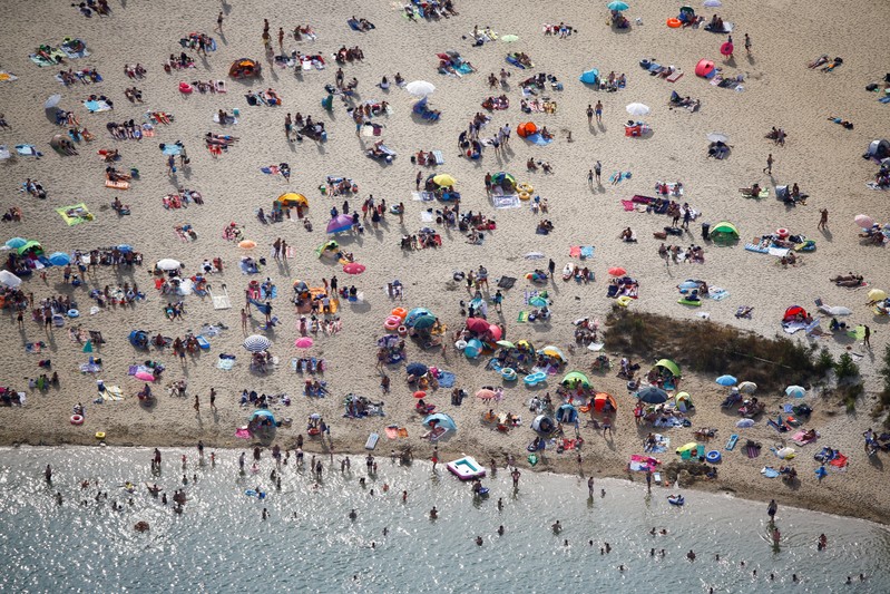 An aerial view shows people at a beach on the shores of lake Silbersee on a hot summer day in Haltern