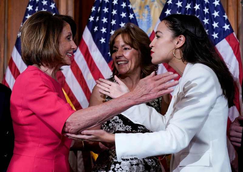 FILE PHOTO: Rep. Alexandria Ocasio-Cortez (D-NY) greets Speaker of the House Nancy Pelosi (D-CA) before a ceremonial swearing-in picture on Capitol Hill in Washington