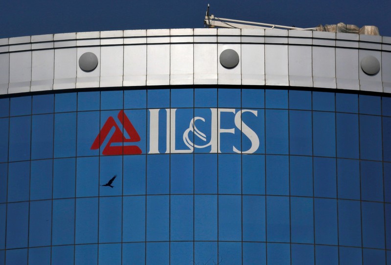 FILE PHOTO: A bird flies next to the logo of IL&FS installed on the facade of a building at its headquarters in Mumbai