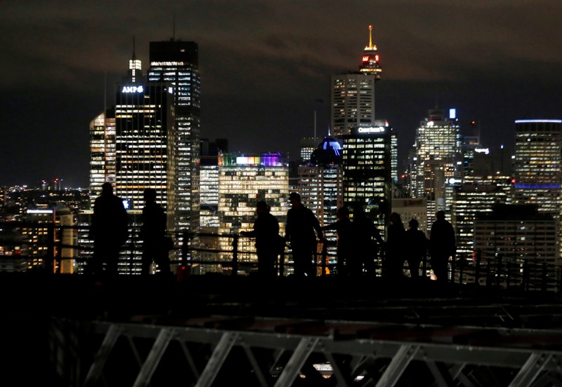 Participants in a Sydney Harbour Bridge walk over the eastern side of the span in front of the city skyline in Australia largest city