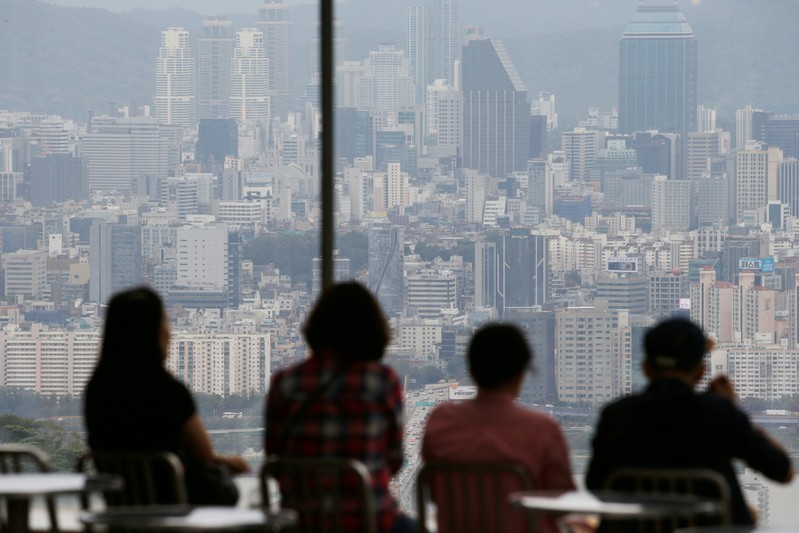 FILE PHOTO: People look at a view of central Seoul from an observatory platform in Seoul