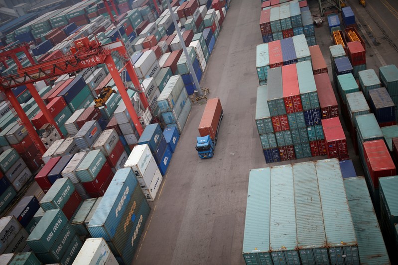 FILE PHOTO: A truck drives between shipping containers at a container terminal at Incheon port in Incheon