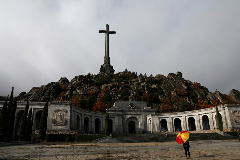 FILE PHOTO: A woman holds an umbrella at the Valley of the Fallen, the mausoleum holding the remains of former Spanish dictator Francisco Franco in San Lorenzo de El Escorial, otuside Madrid