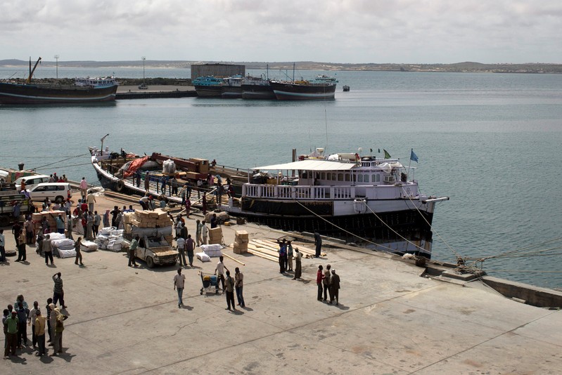 FILE PHOTO: Workers stand at the sea port of the coastal town of Kismayu in southern Somalia