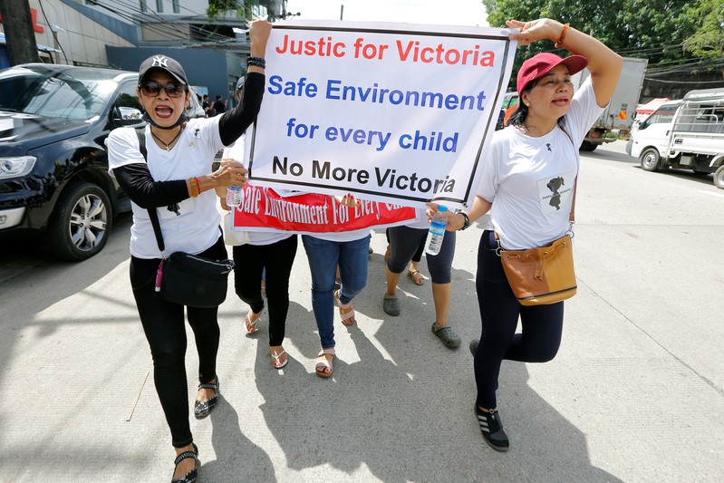 Protesters hold signs during a march demanding justice for a child rape case, in Yangon