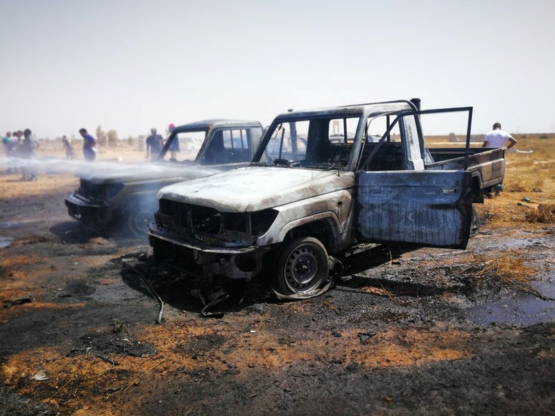 Damaged cars are seen at the site where a car bomb hit a funeral of a former senior military commander at Huwari cemetery in Benghazi