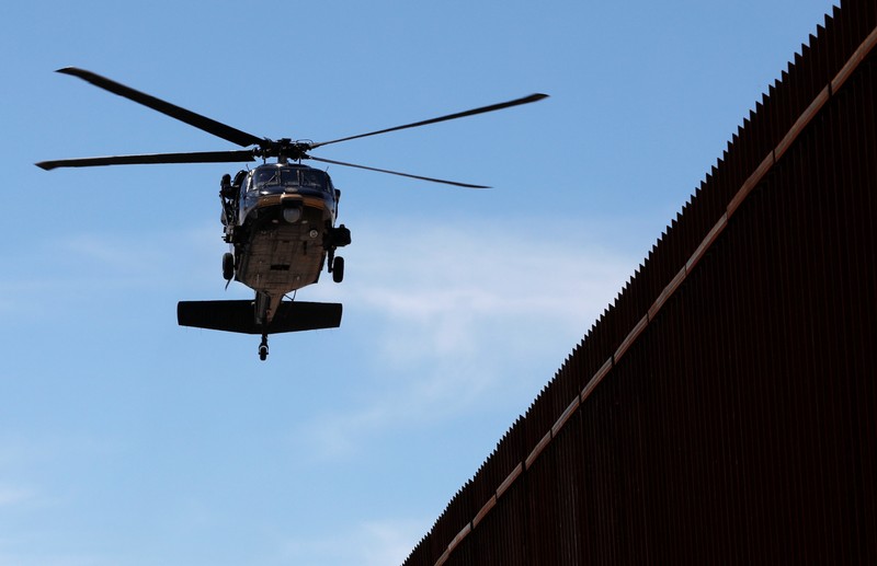 A U.S. security heliporter flies near the border wall during the visit of U.S. President Donald Trump to Calexico, California, as seen in Mexicali