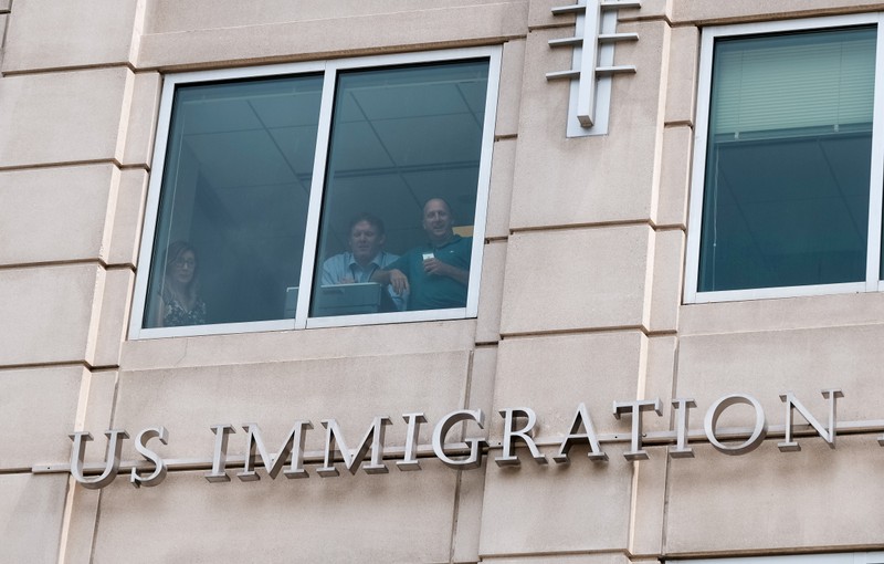 FILE PHOTO: U.S. Immigration and Customs Enforcement employees watch from a window as activists hold the 