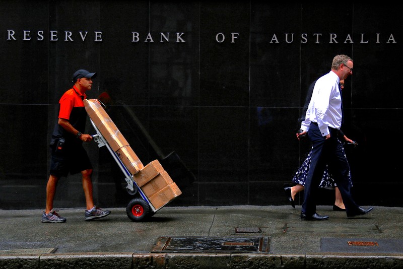 FILE PHOTO: A worker pushing a trolley walks with pedestrians past the Reserve Bank of Australia (RBA) head office in central Sydney