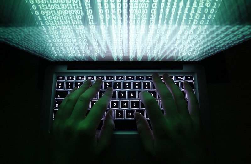 FILE PHOTO: Illustration file picture shows a man typing on a computer keyboard in Warsaw