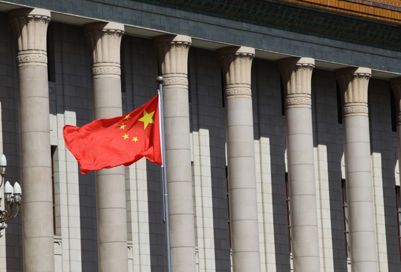 A Chinese national flag flaps in the wind outside the Great Hall of the People in Beijing