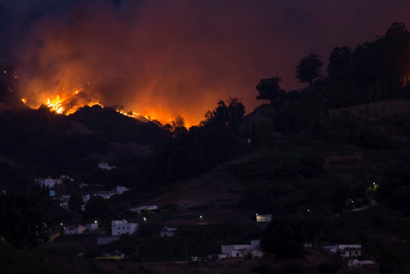 Flames and smoke from a forest fire are seen in the village of Moya on the Canary Island of Gran Canaria