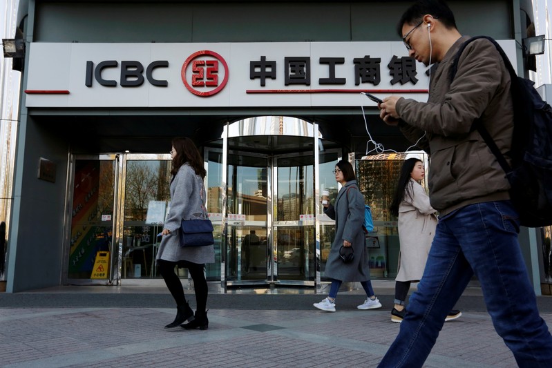 FILE PHOTO: People walk past a branch of Industrial and Commercial Bank of China (ICBC) in Beijing
