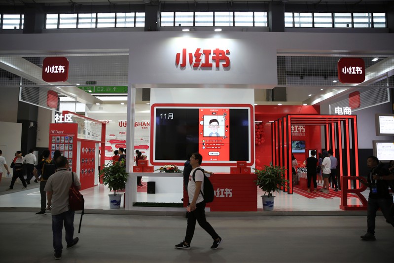 Man walks past the booth of Chinese startup Xiaohongshu at the Big Data Expo in Guiyang