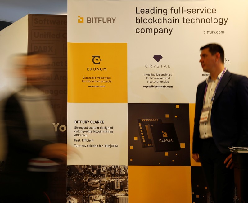 Delegates walk near an exhibition stand of Bitfury, a full-service blockchain technology company, at the Malta Blockchain Summit in St Julian's