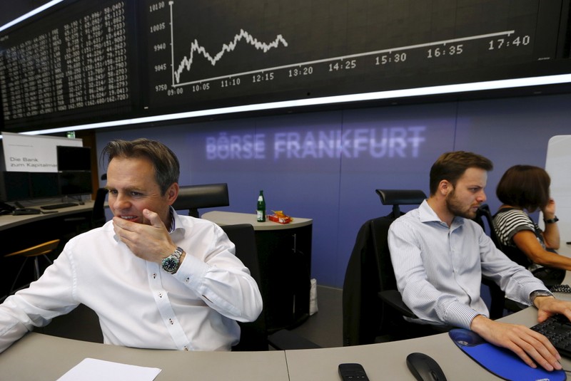 A trader reacts at desk in front of DAX board at the Frankfurt stock exchange