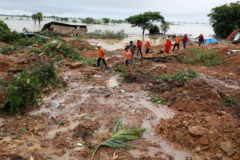 Rescue workers search for bodies under debris and mud after a landslide in Mottama