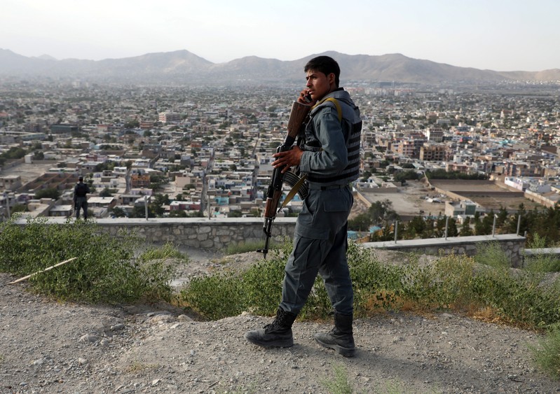FILE PHOTO: An Afghan policeman keeps watch at a hilltop in Kabul