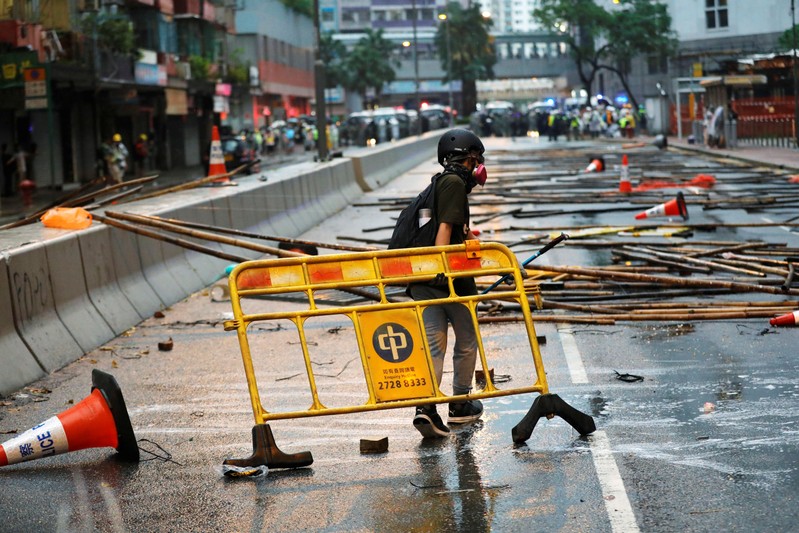An anti-extradition bill protester carries a barricade for blocking the road during a protest in Hong Kong