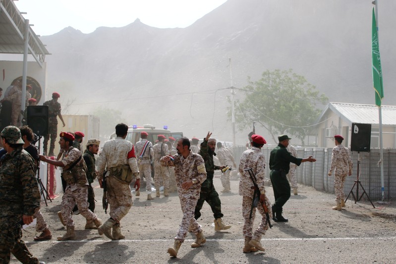 Soldiers rush to help the injured following a missile attack on a military parade during a graduation ceremony for newly recruited troopers in Aden, Yemen