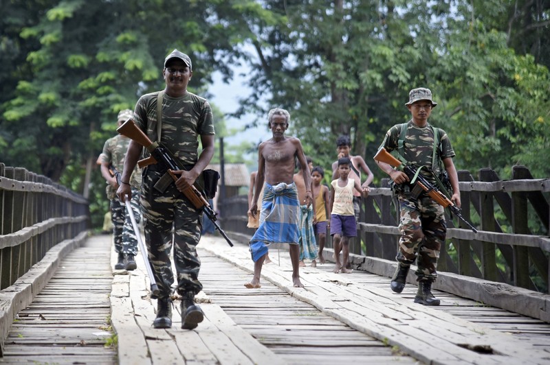 Indian security personnel patrol on a road at Kachari Para village, in Hojai district