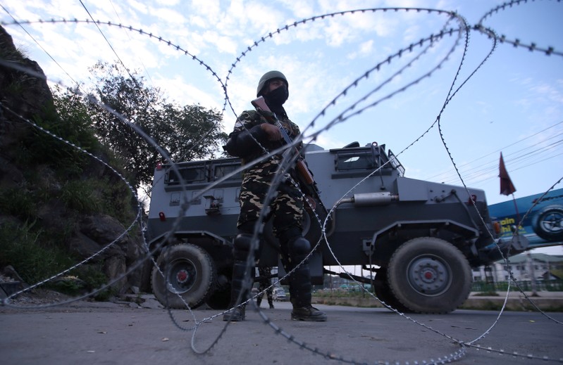 FILE PHOTO: An Indian security personnel stands guard on a deserted road during restrictions after scrapping of the special constitutional status for Kashmir by the Indian government, in Srinagar