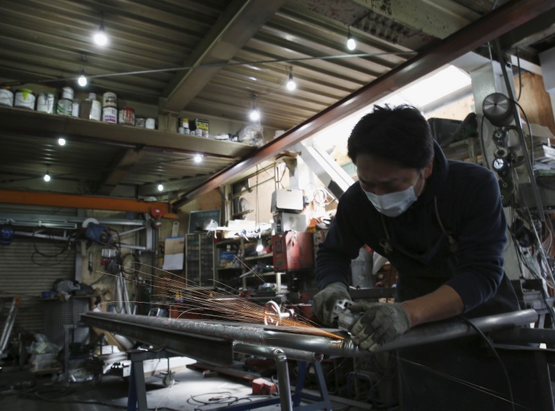 An engineer makes an arm rail for residential buildings inside a metal processing factory at an industrial zone in downtown Tokyo