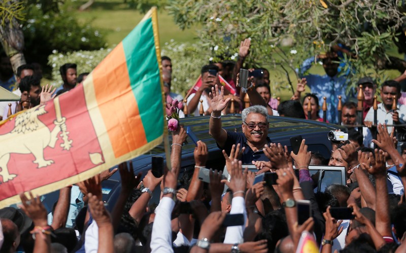 FILE PHOTO: Sri Lanka's former defense secretary Rajapaksa gestures at his supporters after he returned from United States of America in Katunayake